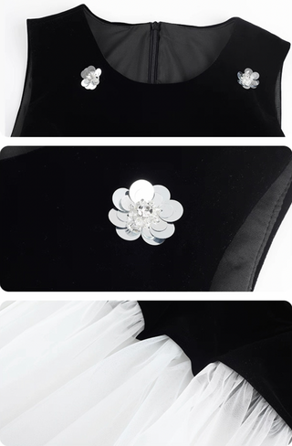 Black top with floral embellishments and white skirt