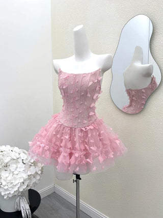 Pink dress on a mannequin with a mirror reflection against a white wall.