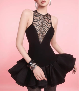 Black dress with intricate detailing on a pink background