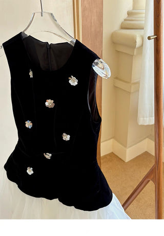Black sleeveless top with floral embellishments on a hanger.