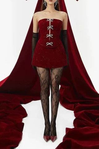 Woman in a red strapless dress with a large red bow in the background