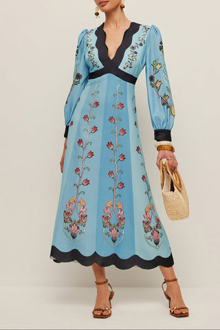 Woman wearing a blue embroidered dress with a plain background