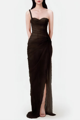 Woman wearing a black evening gown with a slit on a white background