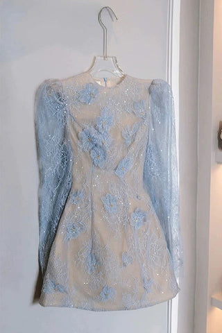 Light blue lace dress on a hanger against a white wall with a handbag and shoes in the background.