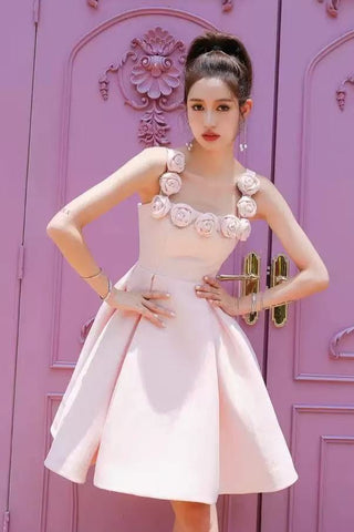 Woman in a pink dress standing in front of a decorative purple door