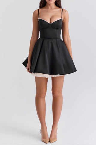 Woman wearing a black dress with a white hem on a light gray background